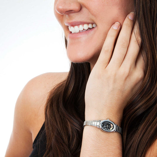 Women's quartz stainless steel watch featuring black oval dial by Mt. Rushmore Black Hills Gold, shown worn
