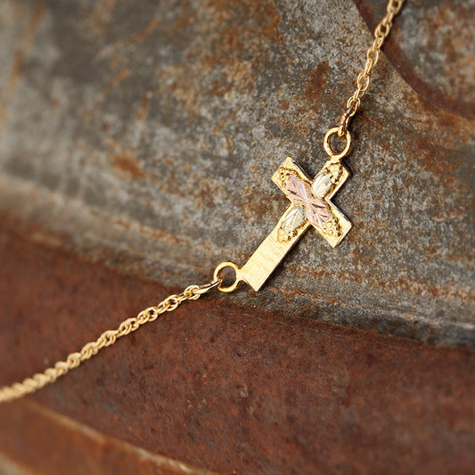 10K yellow gold textured sideways cross necklace by Landstrom's Black Hills Gold, styled view