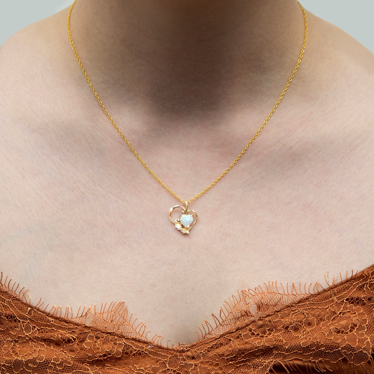 10K yellow gold created heart opal double leaf heart pendant by Landstrom's Black Hills Gold, shown worn