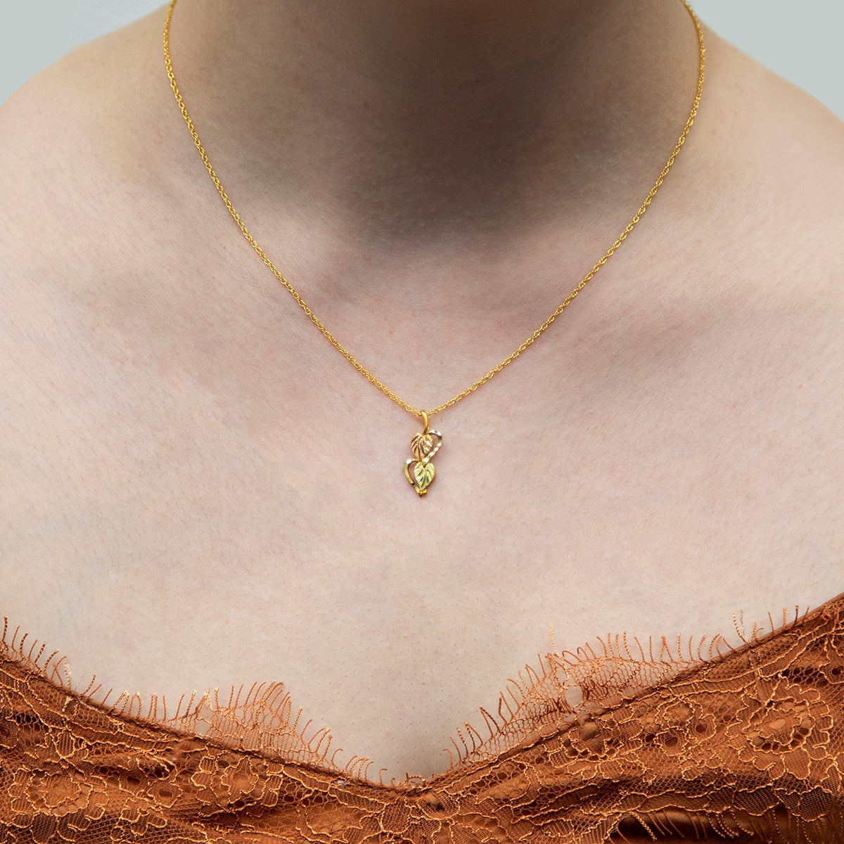 10K yellow gold double leaf half heart pendant by Landstrom's Black Hills Gold, shown worn