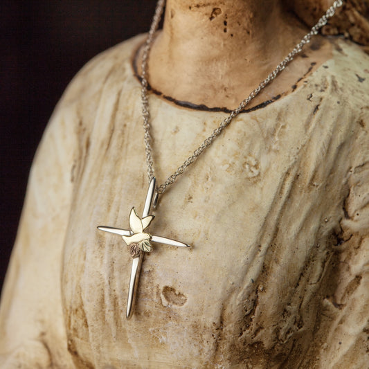 Sterling silver and 10K yellow gold thin cross and dove pendant by Landstrom's Black Hills Gold, styled view