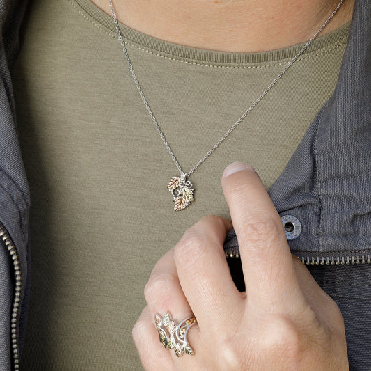 Sterling silver three leaf and grapevine pendant by Landstrom's Black Hills Gold, shown worn