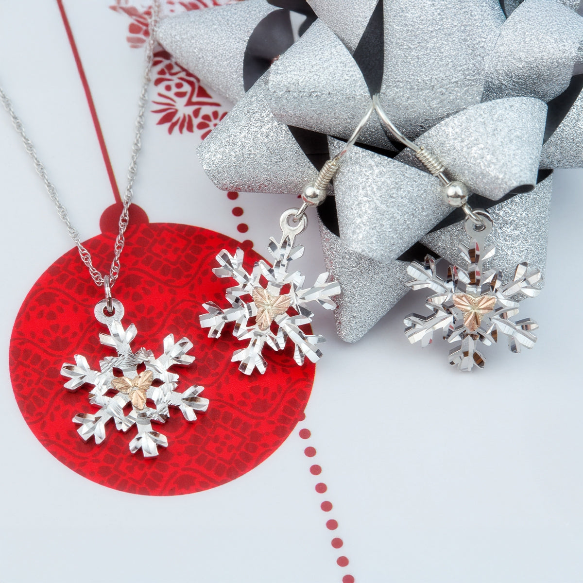 Sterling silver pink leaf snowflake dangle earrings by Landstrom's Black Hills Gold, styled view