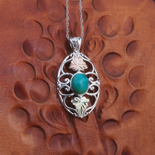 Sterling silver oval turquoise and double leaf pendant by Landstrom's Black Hills Gold, styled view