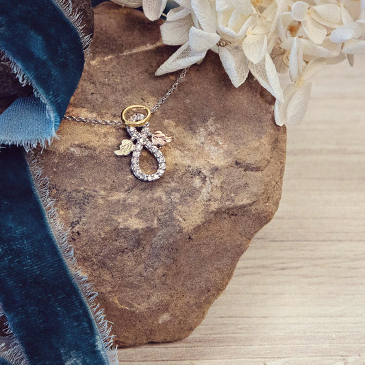Halo infinity angel pendant in sterling silver and 10K yellow gold plating by Landstrom's Black Hills Gold, styled view