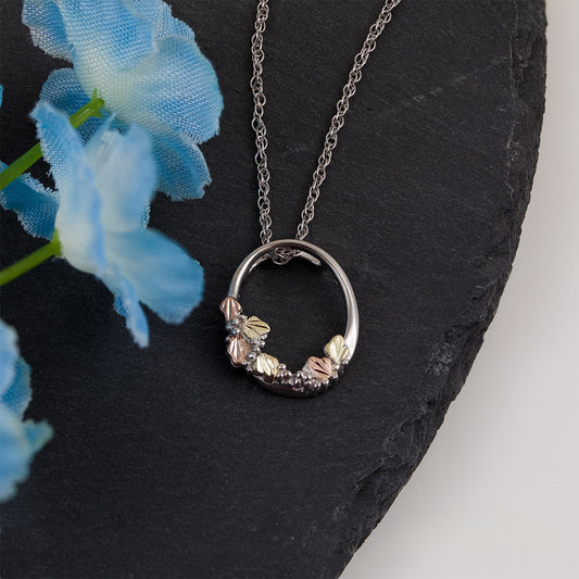 Sterling silver grape and leaf cluster oval pendant by Landstrom's Black Hills Gold, styled view