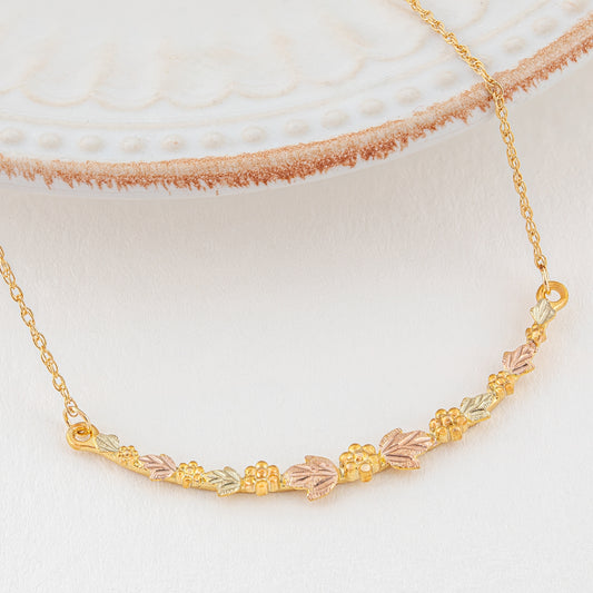 10K yellow gold curved leaf and grape bar necklace by Landstrom's Black Hills Gold, styled view