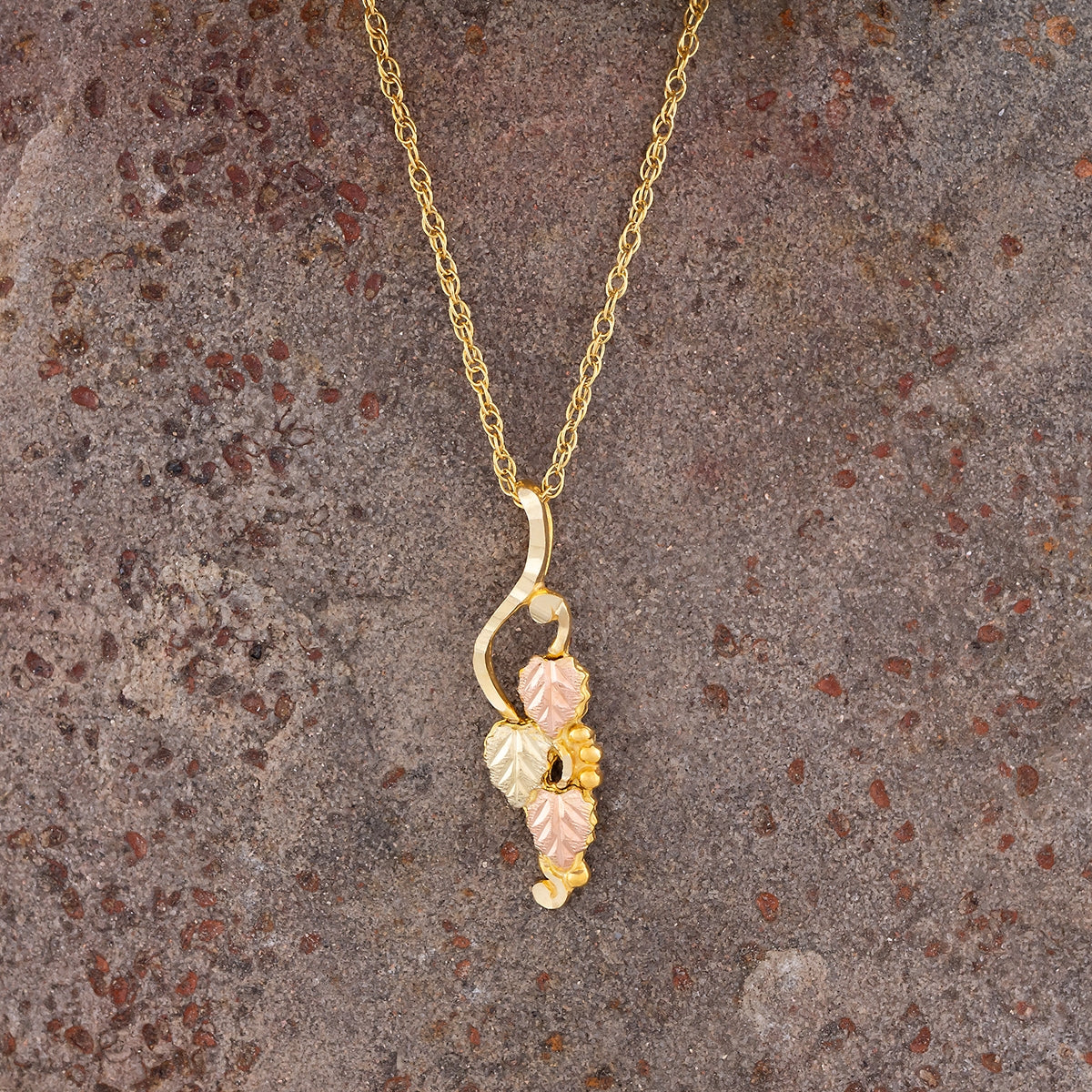 10K yellow gold leaf hanging grapevine pendant by Landstrom's Black Hills Gold, styled view