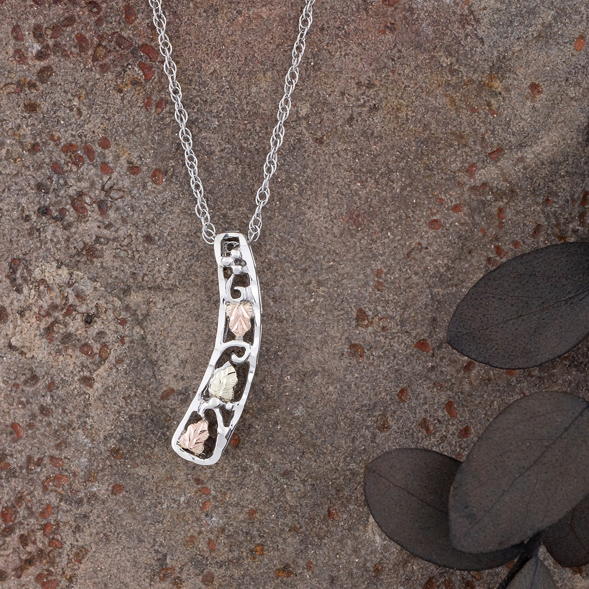 Sterling silver curved vertical bar pendant by Landstrom's Black Hills Gold, styled view