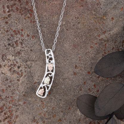 Sterling silver curved vertical bar pendant by Landstrom's Black Hills Gold, styled view