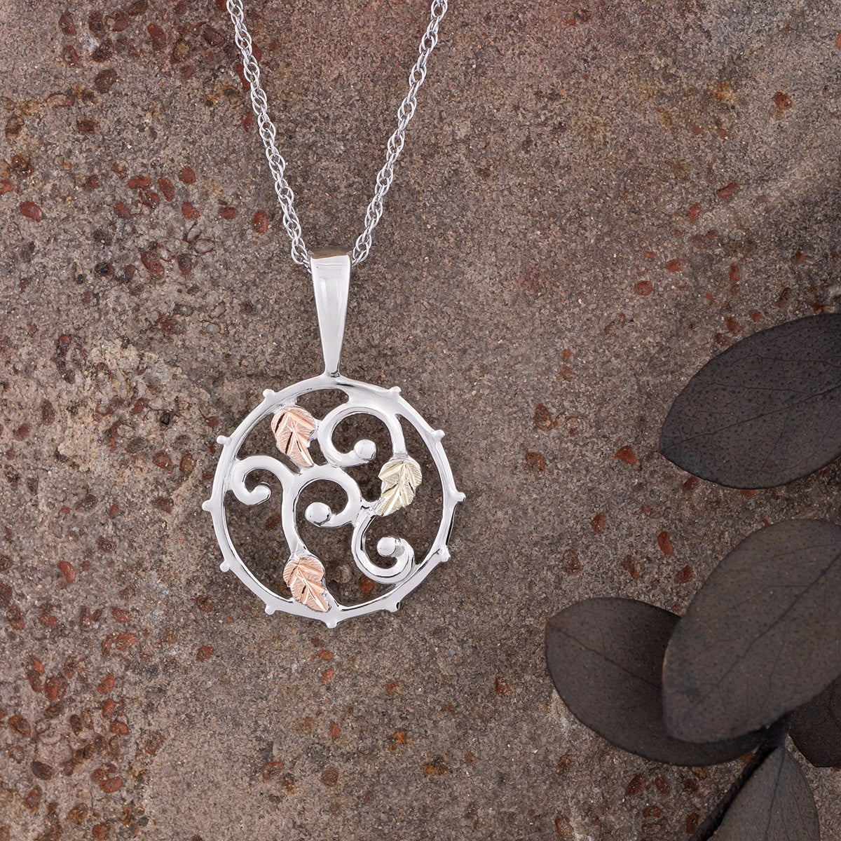 Sterling silver curled vine open circle pendant by Landstrom's Black Hills Gold, styled view