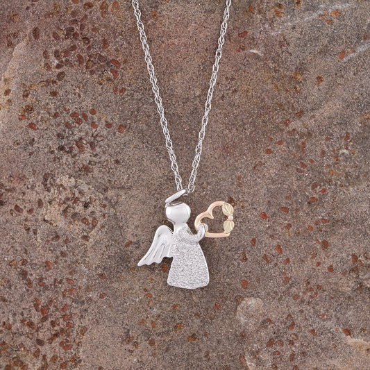 Angel and heart pendant in sterling silver and 10K pink gold by Landstrom's Black Hills Gold, styled view